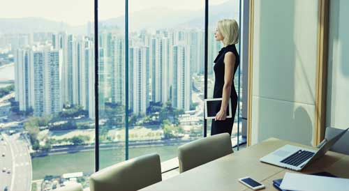 Women CEO looks out of office window