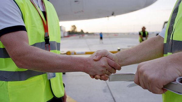 Airport service staff shaking hands