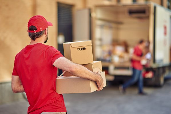 Deliveryman carrying parcels to van