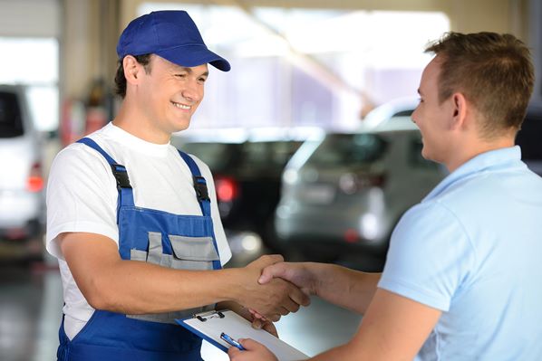 Garage mechanic serving customer