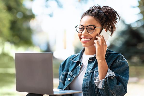 Women on phone with laptop outside