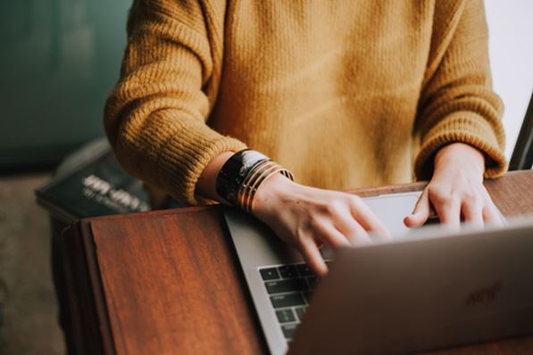 Student writing with laptop