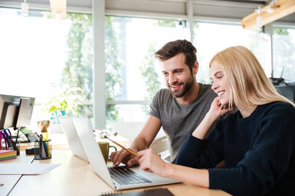 Coworkers using laptop to optimize website