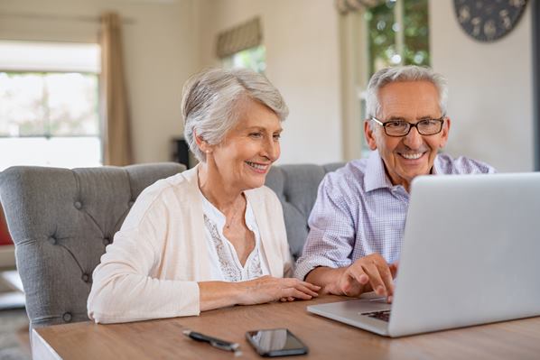 Couple in senior's home using a laptop