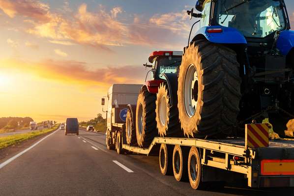 Flatbed truck with cargo of tractors