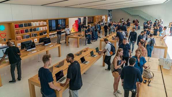 Apple staff helping customers in store