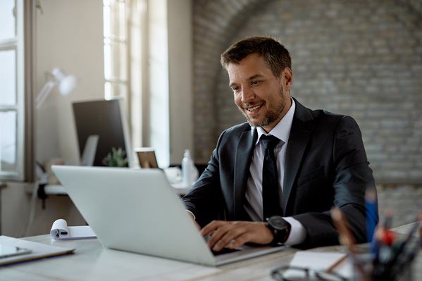 Manager sending an email on his laptop