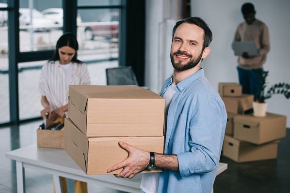 Employees packing boxes before moving office