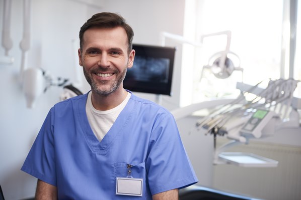 Smiling dentist in his workplace