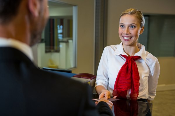Airline attendant greeting passenger 