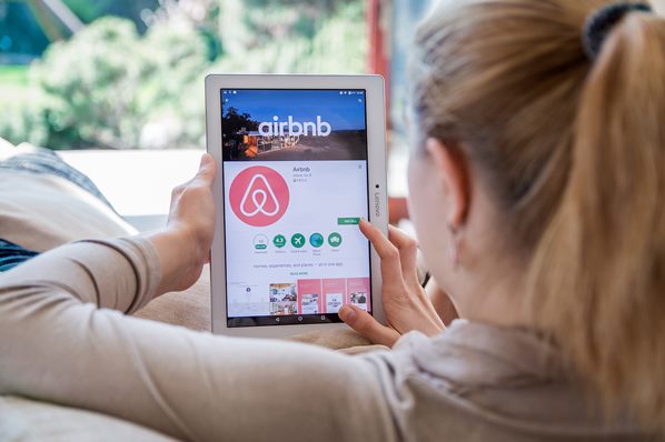 Customer looking at Airbnb website on tablet