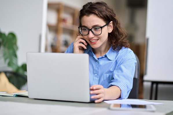 Customer contacting support desk on her laptop and phone