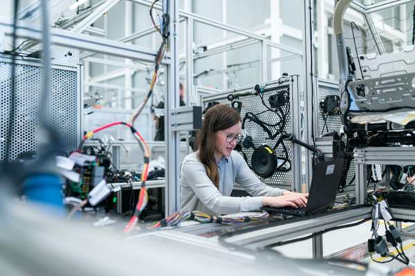 Engineer working on laptop in factory