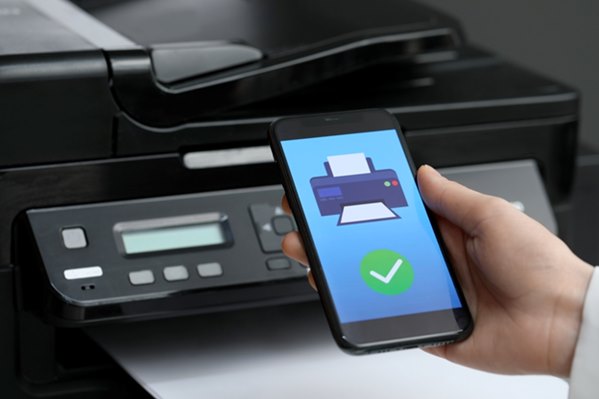 Faxing app on smartphone next to fax machine