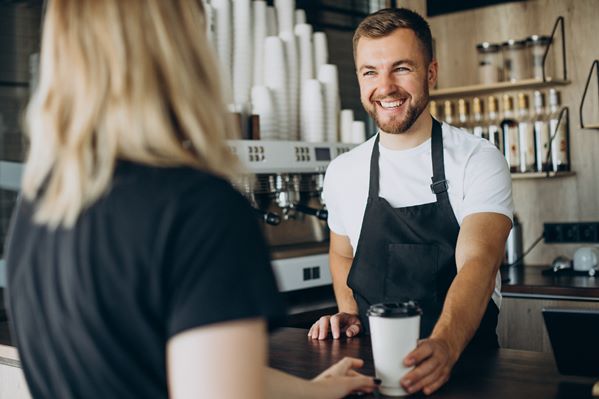 Smiling café owner serving customer