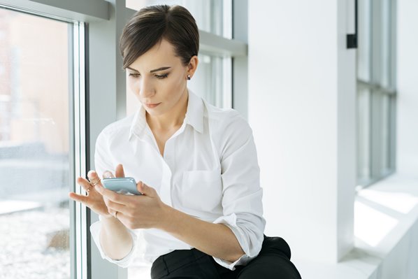 Businesswomen using mobile phone at work
